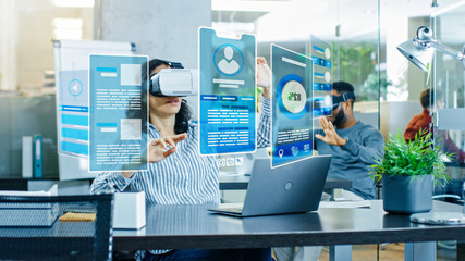 Wall Mural - female virtual reality engineer/ developer wearing virtual reality headset creates content with her 