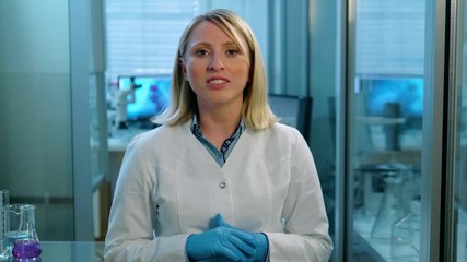 Wall Mural - front view of a female doctor life scientist talking looking directly at the camera.
