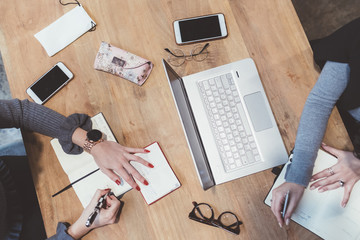 overhead view two young women indoor sitting working desk - business, professional, technology concept