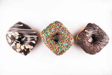 three square doughnut with different toppings isolated on white background. sweet food and unhealthy eating concept