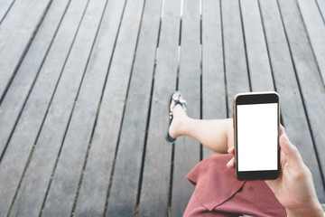 Mockup image of woman hand holding black smartphone with blank white desktop screen.