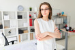 © Ivan Traimak - Beautiful young girl in an office is standing near a table.