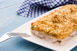 White fish casserole with cheese on blue wooden background.