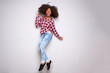 © mimagephotos - Full body excited young black woman jumping with joy over white background