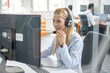 © Bojan - Through glass view of woman with headset working in customer support helpline center