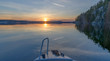 Finland, Laukaa. Boating on a calm lake Saraavesi and sunset. Saraakallio rocks on the right.