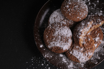 Wall Mural - oatmeal cookies on a black table in castor sugar