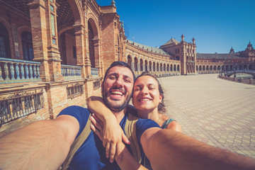 Wall Mural - happy smiling couple take photo selfie in Spain square (plaza de espana) in Sevilla, Spain