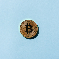 top view of golden bitcoin on blue background