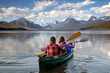 Adventurous traveling couple rowing a boat on a perfect scenic lake in a beautiful national park