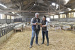 © goodluz - Sheep breeder with veterinary in shed using digital tablet