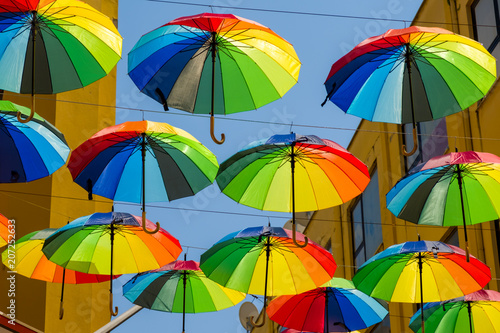 Multicolored, rainbow, umbrellas hung over the street.