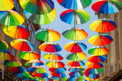 Multicolored, rainbow, umbrellas hung over the street.