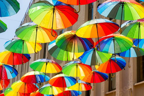 Multicolored, rainbow, umbrellas hung over the street.