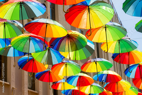 Multicolored, rainbow, umbrellas hung over the street.