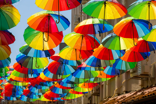 Multicolored, rainbow, umbrellas hung over the street.