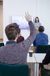 © LStockStudio - Man Raising Hand at Presentation