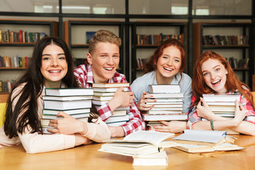 Wall Mural - Group of happy teenagers sitting at the library