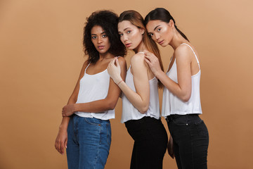 Wall Mural - image of three beautiful women of different nation: caucasian, african american and asian girls in b