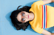 © Jorge Garcia Romeu/ADDICTIVE STOCK - Woman in sportswear and sunglasses lying on blue