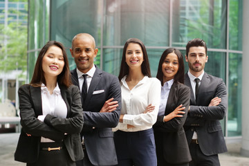 Portrait of business people of different ethnic backgrounds dressed in suits, they smile and cross their arms. Concept of: internationality and career, cooperation and team.