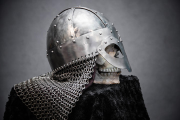 Skull in a Viking helmet, on a black stand, on a gray background