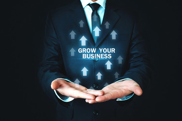 Man holding Grow Your Business words with growth arrows.