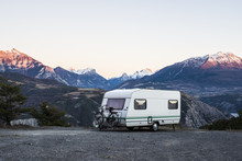 Caravan With A Bike Parked On A Mountaintop With A View On The French Alps Near Lake Lac De Serre-Poncon