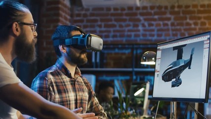 Two men using VR technologies and computer to create video game and developing graphics for movie