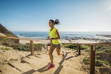 USA, California, Newport Beach, Woman Running Up Stairs