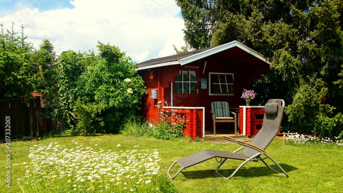 Garten Mit Schwedenrotem Gartenhaus Und Liegestuhl Auf Margeritenwiese Kaufen Sie Dieses Foto Und Finden Sie Ahnliche Bilder Auf Adobe Stock Adobe Stock