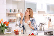 © New Africa - Young attractive woman eating tasty yogurt at table in kitchen