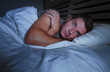 © TheVisualsYouNeed - restless worried young attractive man awake at night lying on bed sleepless with eyes wide opened suffering insomnia sleeping disorder depressed