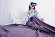 © AS Photo Family - Red haired girl in bed with vr glasses at studio room.