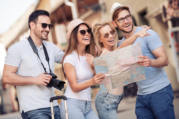 Wall Mural - Happy young friends use map in the city