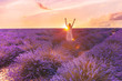 Romantic woman in lavender fields,having vacations in Provence,France. Woman walking in lavender fields at sunset.the girl stands in lavender fields with her hands up, illuminated by sunset sun rays