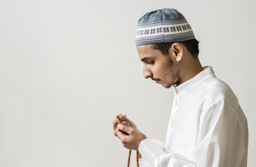 Wall Mural - Muslim man praying with tasbih during Ramadan