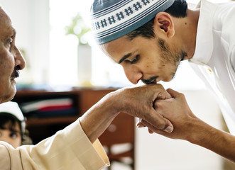 Wall Mural - Young Muslim man showing respect to his father