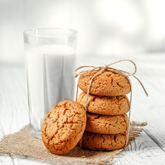 A glass of milk and delicious oatmeal cookies. Square. The concept is healthy food, breakfast, vegetarianism.