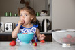 © Lisa Tichané - Toddler eating strawberries at kitchen counter