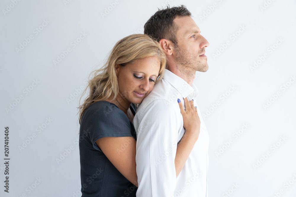 Woman hugging man from behind, representing emotional support and comfort.
