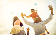 © Mirko Vitali - Happy multiracial families group with parents and children playing with kite at beach vacation - Summer joy concept with mixed race people having fun together at sunset  - Warm bright sunshine filter