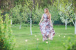 © Volodymyr Shcherbak - Young woman enjoying spring in the green field with blooming trees