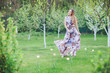 © Volodymyr Shcherbak - Young woman enjoying spring in the green field with blooming trees