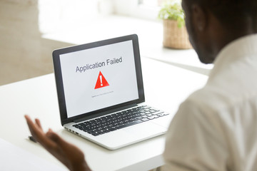 Frustrated unhappy worker getting application fail notice at laptop screen, malware program causing mistake operation problem leading to information leakage, data loss. Online virus, app crash concept