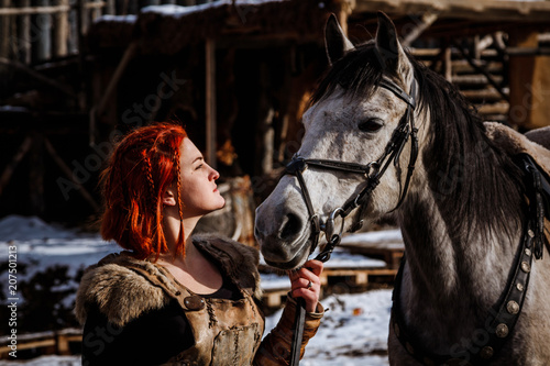 Fotografie, Obraz Red-haired woman with a faithful horse preparing for battle