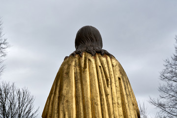 Jesus christ statue with golden overcoat from behind