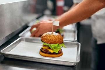 Wall Mural - Burger Restaurant. Closeup Chef Cooking Burgers In Kitchen.