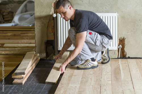 Young Handsome Professional Carpenter Installing Natural Wooden