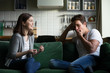 © fizkes - Young husband yawning getting bored listening to excited wife talking for a long time, tired boyfriend not interested in girlfriend gossiping sitting on couch at home, boring conversation concept